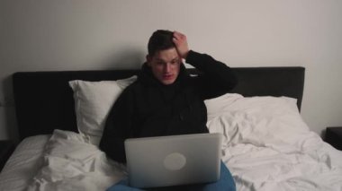 Heyecanlı adam yatak odasındaki laptopta harika haberleri okuyor. Şaşırtıcı erkek profesyonel kazanan yeni iş fırsatı, ödül ikramiyesi, finansal piyasa büyümesini kutluyor