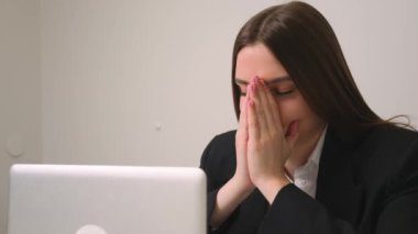 Kapatın. Ev ofisinde dizüstü bilgisayara bakan yorgun üzgün iş kadınının portresi. İşindeki hataları düşünen üzgün bir kadına yaklaş. Laptop görünümlü üzgün kız portresi. Bunalımlı