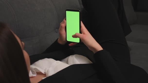 Primer plano de la mujer acostada en un sofá usando Smartphone con Green Mock-up Screen. Mujer usando el teléfono móvil chromakey, Deslizamiento, Desplazamiento. Internet Redes Sociales Navegar, ver contenido. — Vídeos de Stock