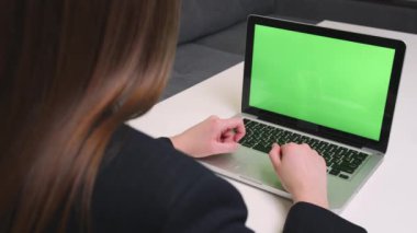 Arkadan bak. Heyecanlı iş kadını kazananı dizüstü bilgisayarın yeşil ekran kromatına bakıyor. İnternetteki başarısını evde ya da ofiste kutluyor. Kadın yeni iş fırsatları buluyor, e-postada iyi haberler okuyor.