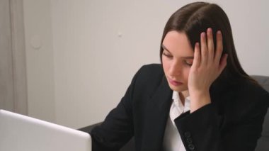 Ofiste dizüstü bilgisayara bakarken yorgun ve üzgün iş kadınının yüzünü kapat. İşindeki hataları düşünen üzgün bir kadına yaklaş. Laptop görünümlü üzgün kız portresi. Bunalımlı çalışan