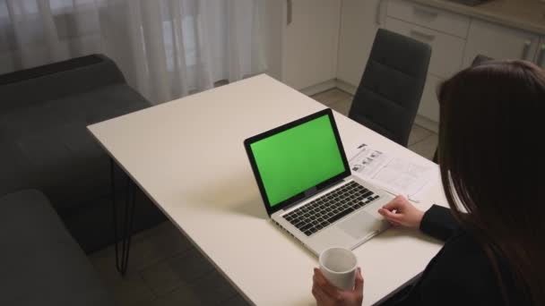 Mujer de negocios caucásica tiene videollamada en el ordenador portátil con cromakey pantalla verde en la oficina. Mujer que tiene videoconferencia en línea en el lugar de trabajo remoto en la oficina en casa. — Vídeos de Stock
