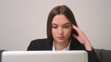 Kapatın. Ev ofisinde dizüstü bilgisayara bakan yorgun üzgün iş kadınının portresi. İşindeki hataları düşünen üzgün bir kadına yaklaş. Laptop görünümlü üzgün kız portresi. Bunalımlı