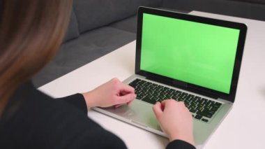 Kadın çalışan evde ya da ofiste oturan kromakey 'e bakıyor. Yeşil ekranlı masaüstü bilgisayarı olan iş kadını, içeriği izleyen kadın, dizüstü bilgisayarında görüntülü konuşma yapıyor..