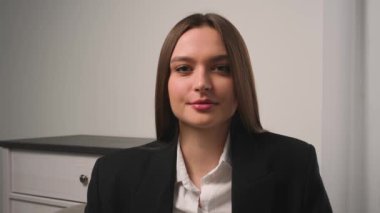 Kendine güvenen genç ve çekici bir iş kadınının portresi kameraya başarılı bir şekilde bakıyor.