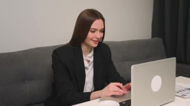 Evde ya da ofiste dizüstü bilgisayar kullanan gülümseyen kadın. Sosyal ağlarda sohbet ederek, iş için yararlı bilgiler arayarak ya da internet konsepti üzerinde çalışarak zaman harcayın.