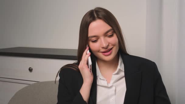 笑顔のビジネスマンは、自宅のオフィスで電話を話しています。ソファの上で女の子が電話を話している肖像画。スローモーションで電話をかける笑顔の女性. — ストック動画