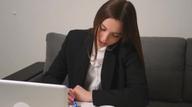 Projede çalışan genç bir iş kadını telefonda konuşuyor. Kadın yönetici iş görüşmesi yapıyor cep telefonu yazma görevleri ev ofisinde yalnız çalışan notlar üzerine.