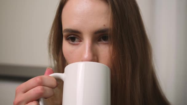 Ritratto di donna d'affari soddisfatta che beve tè a casa. Donna attraente che si gode una tazza di caffè a casa al rallentatore. Donna che tiene in mano una tazza di tè al mattino — Video Stock