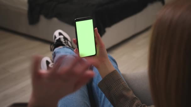 Femme agitant sa main tenant smartphone écran vert chromatique a appel vidéo bavardage sur le téléphone à la maison ou au bureau. Gadgets concept de personnes. — Video