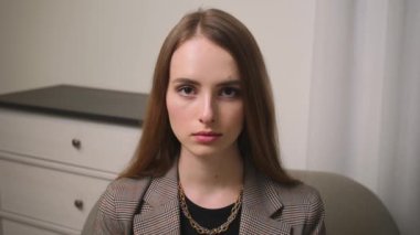 Kendine güvenen genç ve çekici bir iş kadınının portresi kameraya bakıyor.