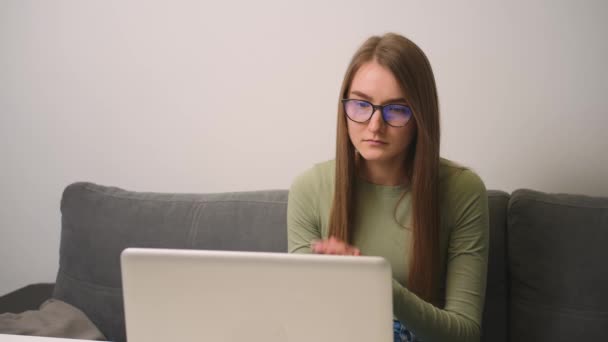 Mujer molesta en gafas usando el ordenador portátil se siente frustrado loco por el problema, la lectura de malas noticias en las redes sociales. Mujer que trabaja en casa u oficina. — Vídeos de Stock