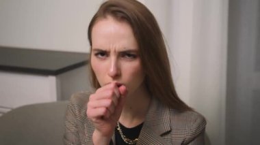 - Yakın çekim. Öksüren genç ve güzel bir kadının portresi. İş kadını ofiste oturuyor..