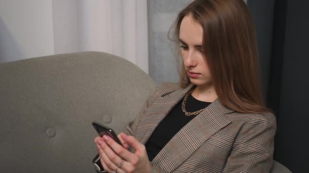 Portrét ženy pomocí telefonu, sledování obsahu, prohlížení internetu, žena kašle sedí na gauči doma. — Stock video