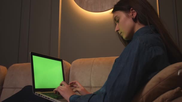 Focused woman pisząca na laptopie zielony ekran chromakey, przeglądająca internet, studiująca lub pracująca na kanapie w biurze. — Wideo stockowe