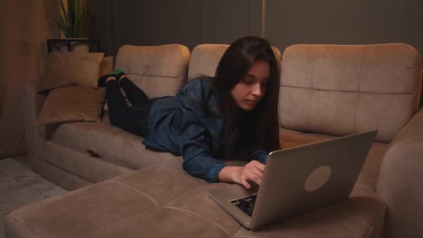 Wanita lelah berbaring di sofa selesai bekerja pada pesan mengetik laptop, wanita chatting di komputer browsing media sosial internet belajar atau bekerja online di rumah. — Stok Video