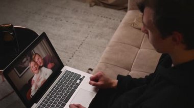 El sallayan genç adamın dizüstü bilgisayarında arkadaşları evdeki kanepede otururken videosu var..