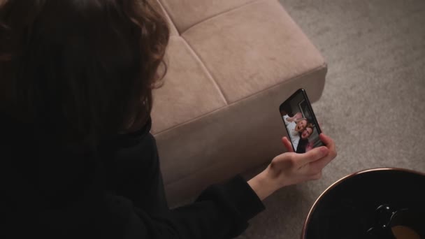 Closeup. Man has video call chatting on phone with friends sitting on couch at home. — Vídeos de Stock