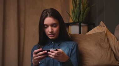 Rahat kız elinde akıllı telefon, mobil uygulamalar kullanıyor oyun oynuyor, evde video izliyor..