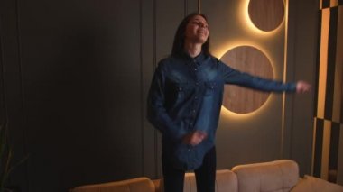 Beyaz kadın evdeki kanepede dans ediyor..