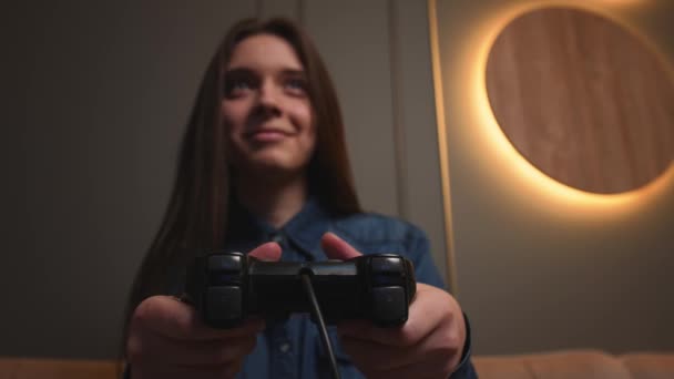 Primer plano. Retrato de una mujer jugando un videojuego en casa. Emocionada mujer gamer sentado en un sofá, jugando videojuegos en. — Vídeos de Stock