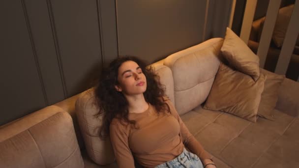 Приваблива молода жінка відпочиває на дивані, здорова спокійна леді розслабляється на зручному дивані, відчуваючи стрес безкоштовно в домашньому лаунжі один — стокове відео
