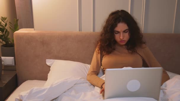 Pretty caucasian woman working laptop on bed at home. focused woman work laptop. — Stock Video