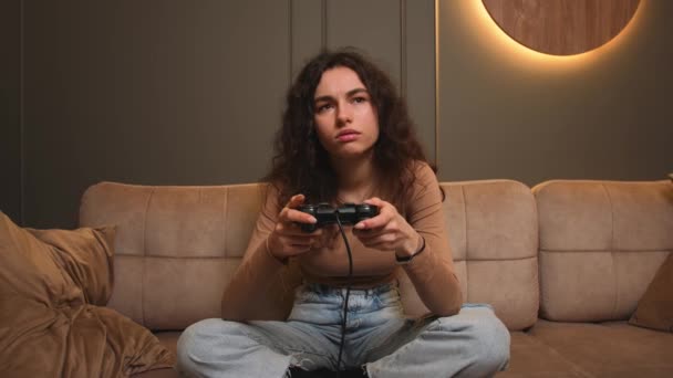 Verveelde Vrouw geeuwt thuis 's avonds een videospel. verveeld gamer vrouw zitten op een bank, het spelen van video games op. — Stockvideo