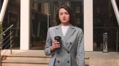 Sokakta kahve içen beyaz bir kadın. Kadın şehirde dolaşıyor..