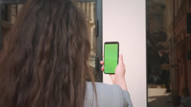 Closeup dívka, která má videohovor pomocí mobilního telefonu se zelenou obrazovkou venku. Žena používající smartphone s barevnou obrazovkou na ulici. Neznámá dáma drží před domem telefon.. — Stock video