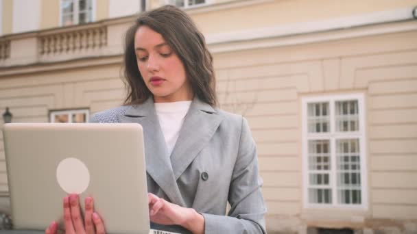 Ritratto di bella donna caucasica che usa il computer portatile per strada. — Video Stock
