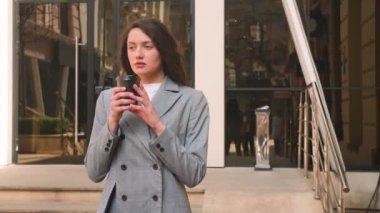 Güzel beyaz kadın sokakta kahve içiyor..