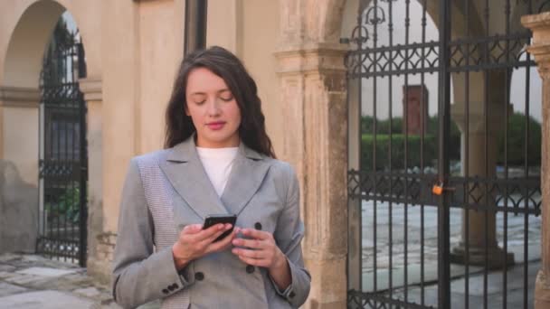 Portret uśmiechniętej bizneswoman rozmawiającej przez telefon na ulicy. kobieta mając telefon rozmowa odkryty — Wideo stockowe