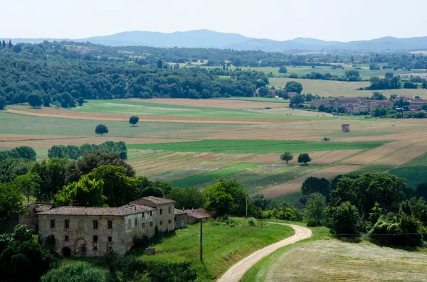 Toskánská krajina se starou budovou na poli. Itálie. — Stock fotografie
