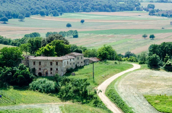 Old building against green field and trees, Tuscany Italy — Stock Photo, Image