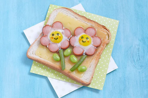 Funny toast with cheese, sausages, quail eggs and edamame — Stock Photo, Image