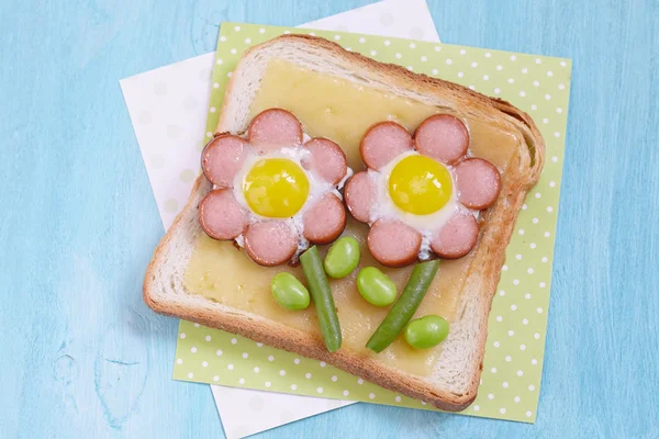 Funny toast with cheese, sausages, quail eggs and edamame — Stock Photo, Image