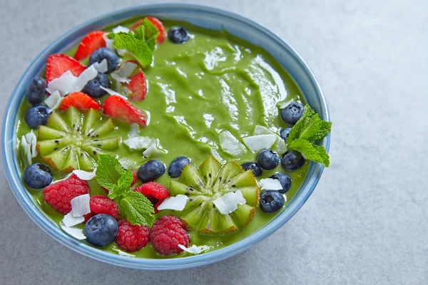 breakfast green smoothie bowl with fruits and berries