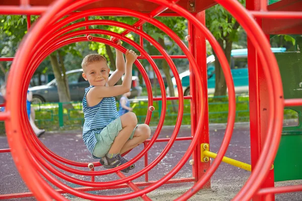 Rapaz bonito brincando em túnel no parque infantil — Fotografia de Stock
