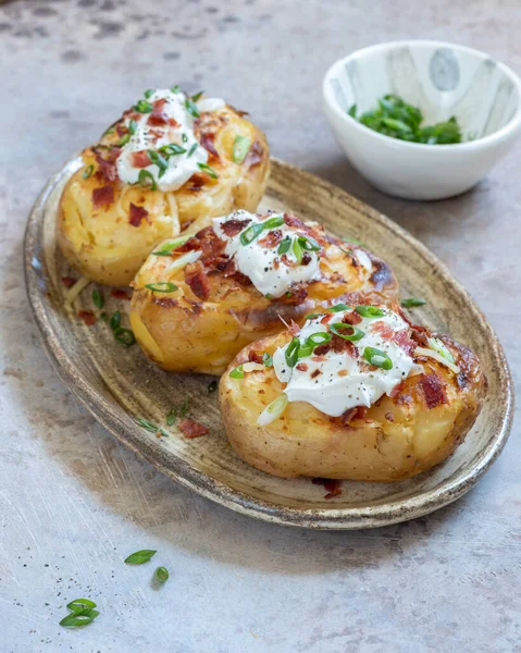 Baked potatoes with bacon, green onion and cheese — Stock Photo, Image