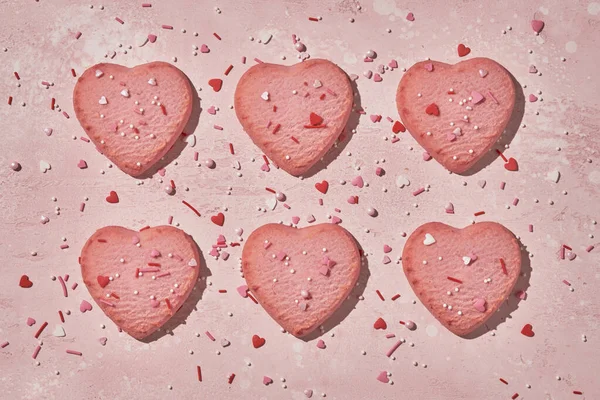 Biscuits décorés en forme de coeur sur fond rose — Photo