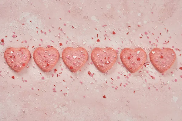 Biscoitos decorados em forma de coração no fundo rosa — Fotografia de Stock