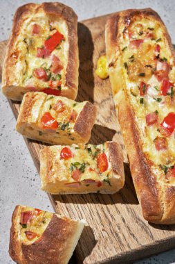 Kahvaltı için jambon, yumurta ve peynirle doldurulmuş ekmek tekneleri.