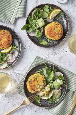 Uskumru kekleri roket, ıspanak ve su teresi salatasıyla servis edilir..