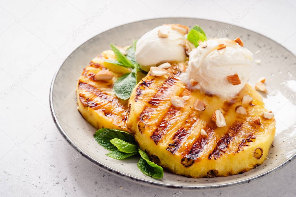 Grilled pineapple with scoops of vanilla ice cream