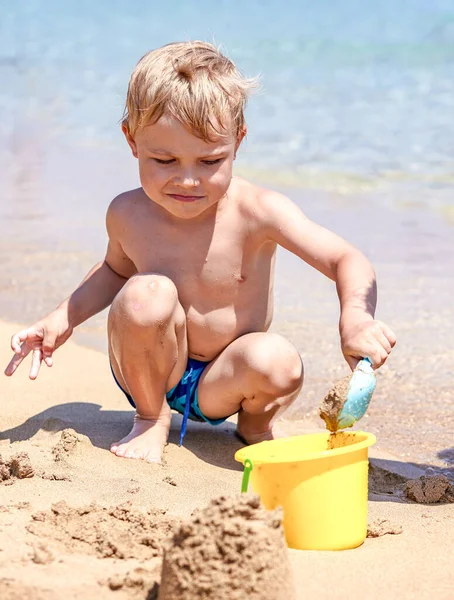 Ragazzo che gioca nella sabbia sulla spiaggia — Foto Stock