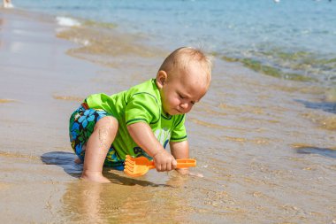 Kumsalda oynayan bir çocuk.