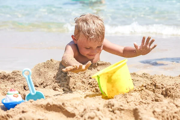 Ragazzo che gioca nella sabbia sulla spiaggia — Foto Stock