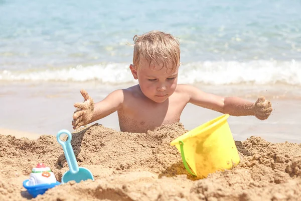 Niño jugando en la arena en la playa —  Fotos de Stock