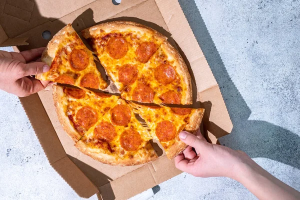 İnsanlar Pepperoni Pizza 'dan dilimler alıyor.. — Stok fotoğraf